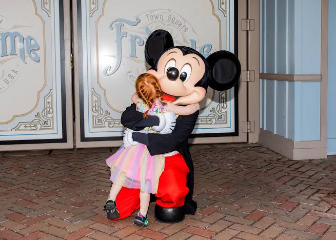 Niño feliz abrazando a un personaje en Disneyland Paris
